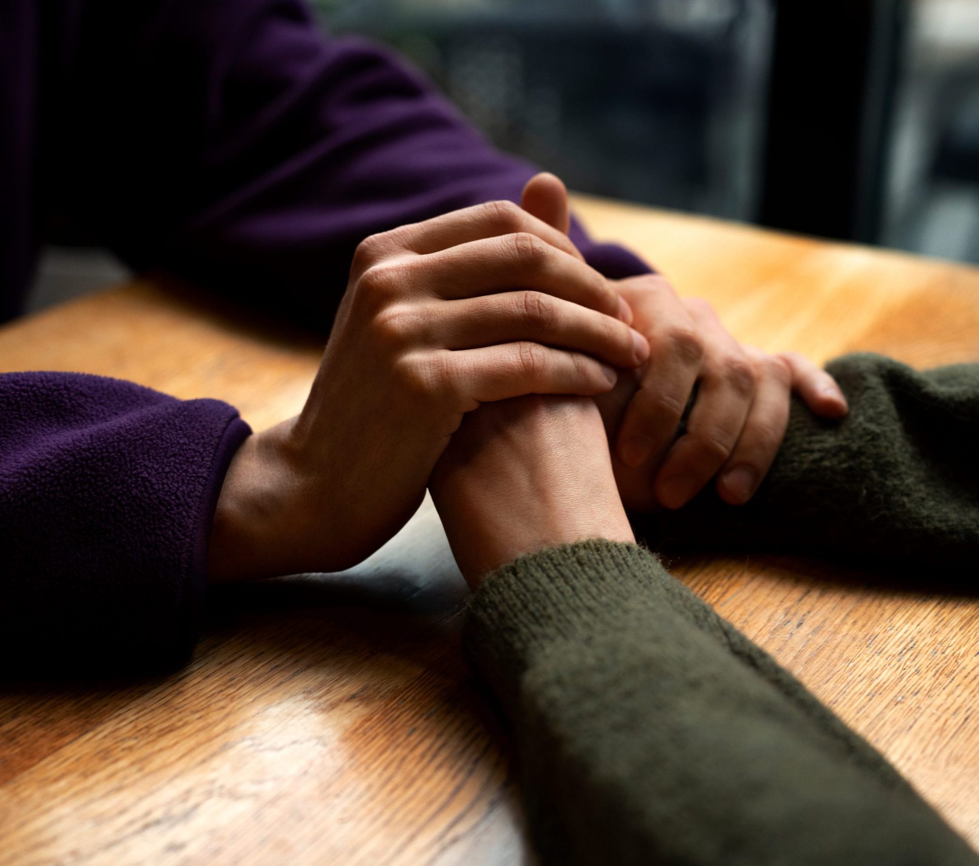 Two people holding hands in support